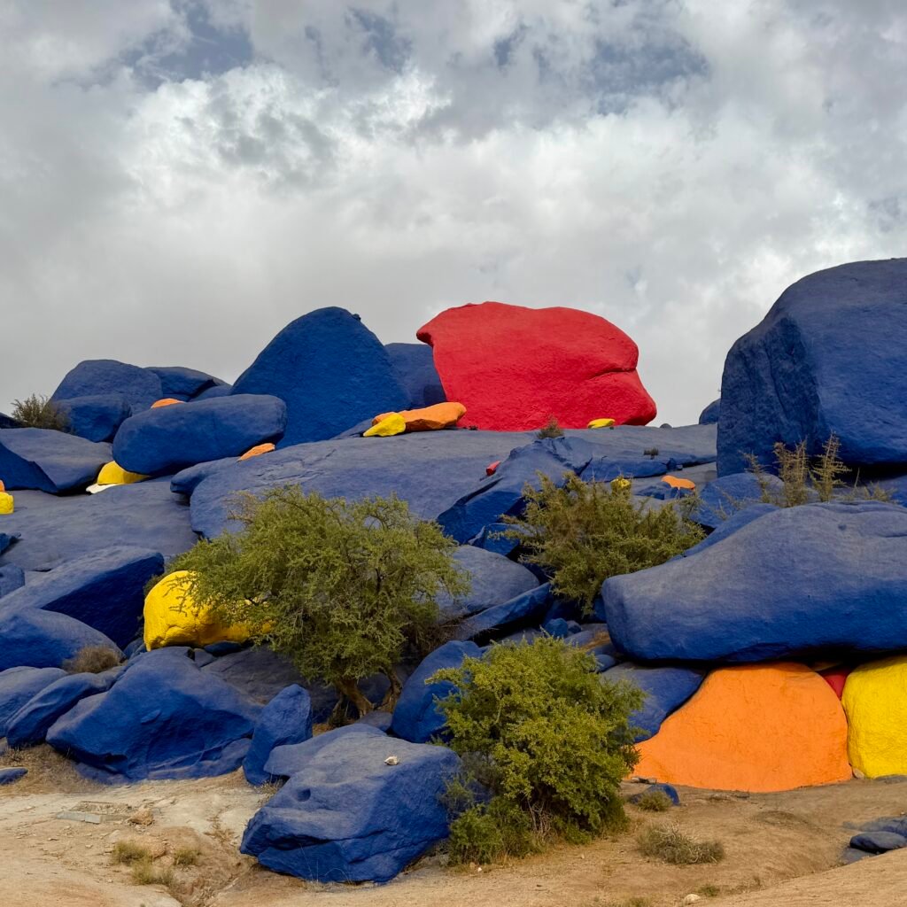 Wide view of colorful painted blue, red, and yellow boulders near Tafraoute, Morocco