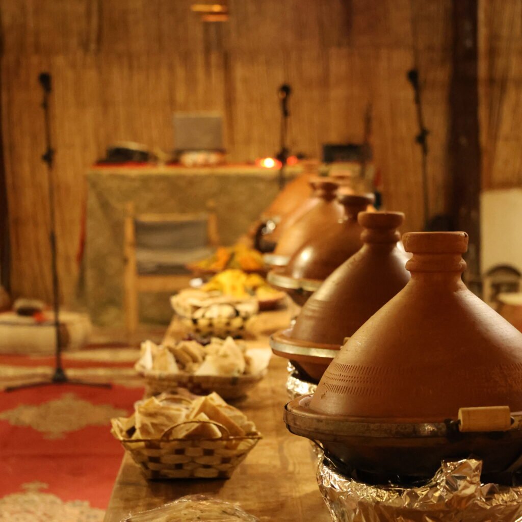 Traditional clay tagine pots lined up along a wooden buffet table ready for dinner service
