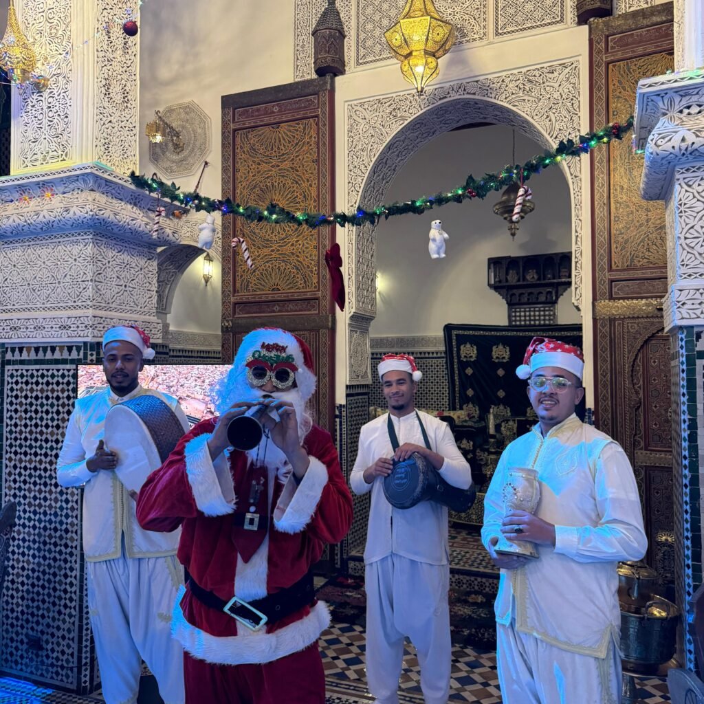 Santa performer playing a wind instrument with traditional Moroccan musicians in a riad