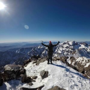 Person celebrating on snowy mountain peak