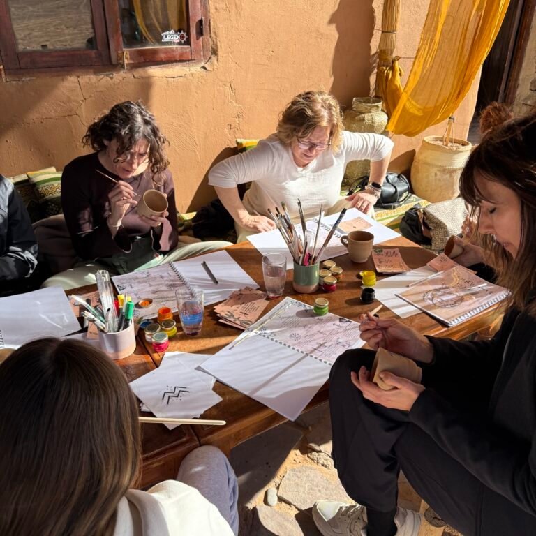 Participants painting ceramic cups outdoors.