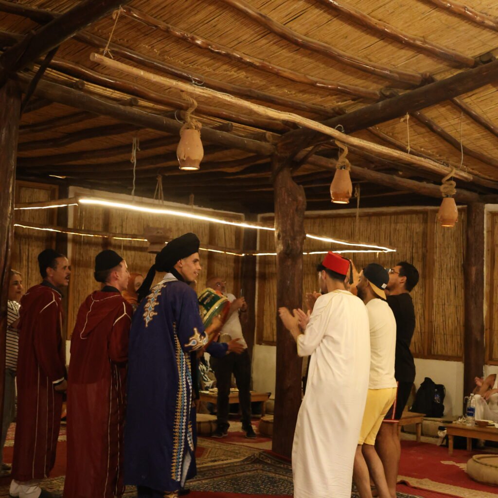 Traditional Moroccan musicians and performers interacting with guests during an evening cultural show