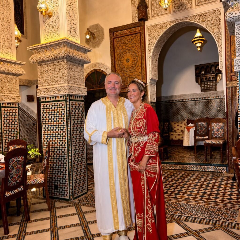 Couple in Moroccan wedding attire inside an ornate riad