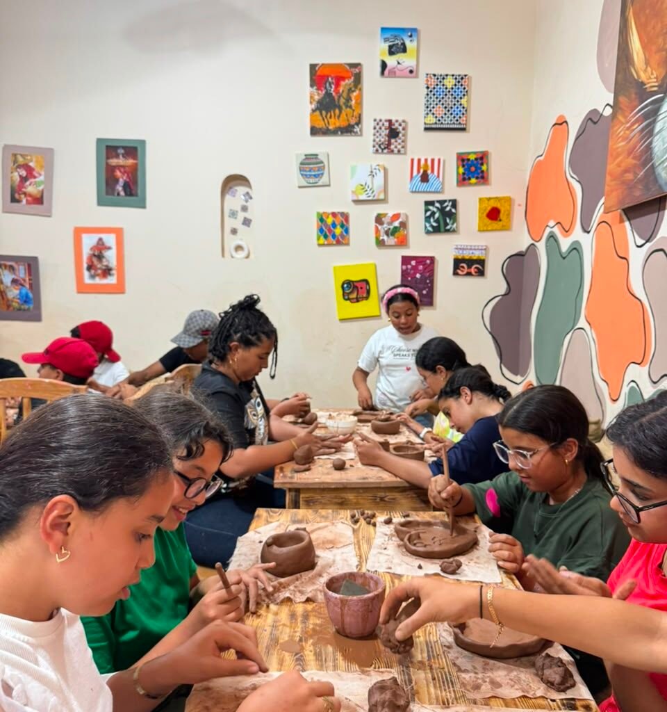 Group of travelers practicing clay hand-building techniques during a pottery workshop